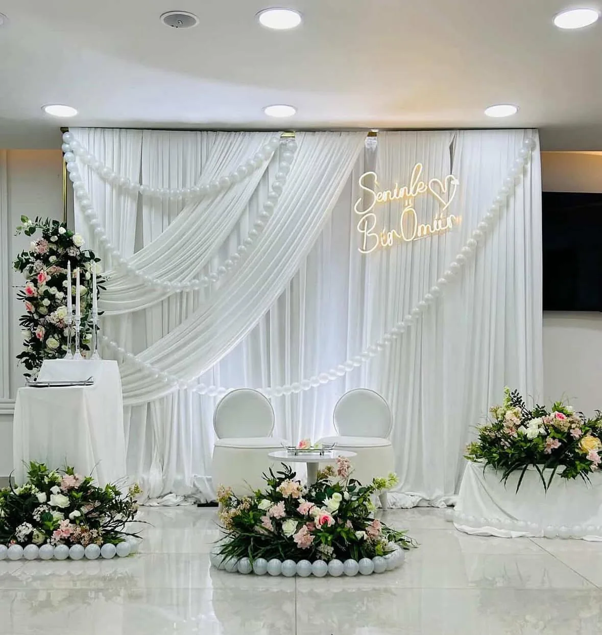 İnci ve pastel çiçeklerle hazırlanan beyaz söz sahnesi